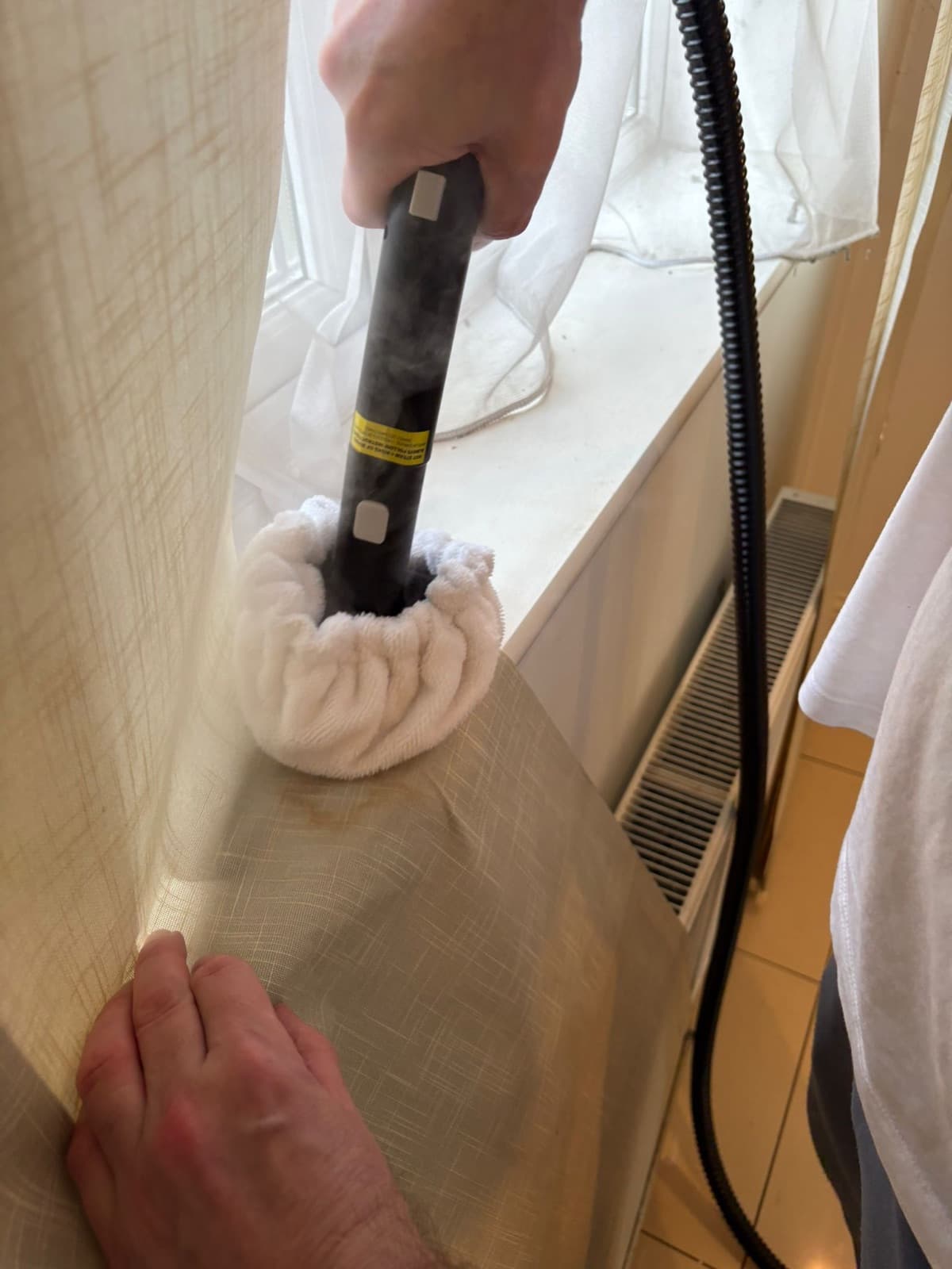 Steam cleaning being applied to an upholstered surface